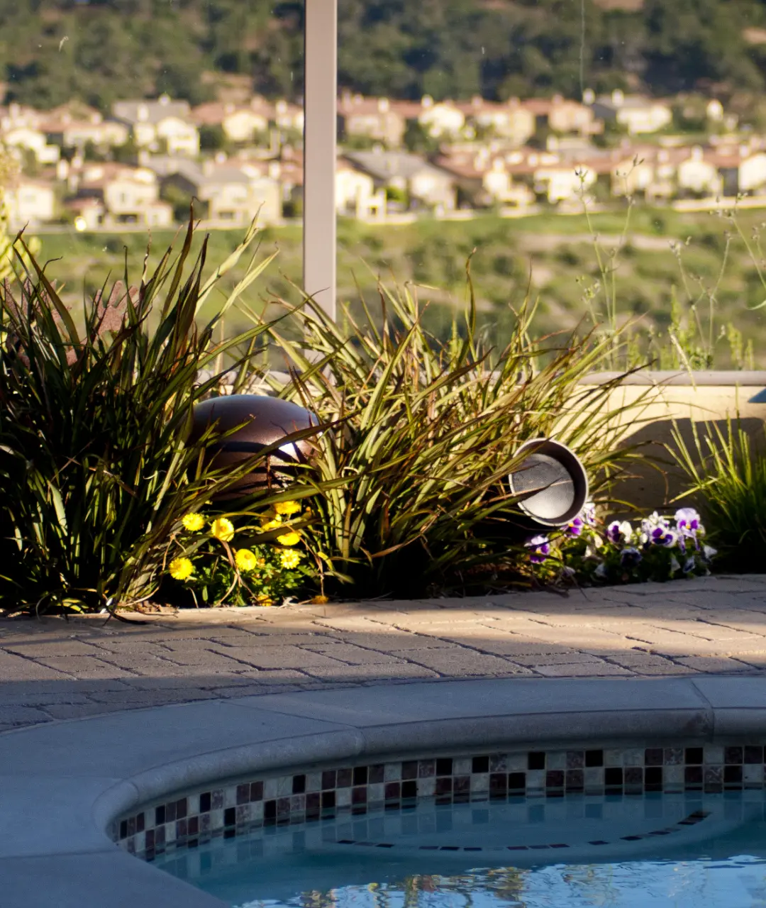 Gerichtete Gartenlautsprecher. Erdspießsystem mit Subwoofer von Sonance am Pool. Versteckt in der Vegetation.